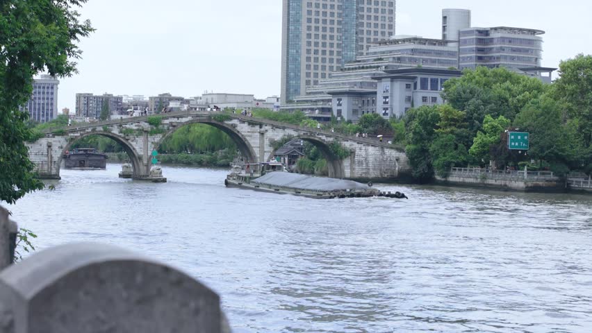 Gongchen Bridge on the Grand Canal in Hangzhou, a UNESCO World Heritage site with cargo ships passing by.