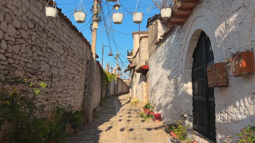 Historic Gorica quarter in Berat.Tiered Ottoman residential stone houses, hotels, narrow streets with red-tiled roofs in summer time. Blooming flowers and old cobblestone streets