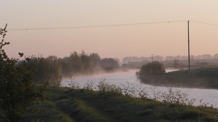 Mist rising from a river in the still air at dawn in Cambridgeshire, England.