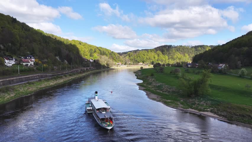 Aerial view of a historic paddle steamer cruising up the Elbe River through the picturesque Elbe Valley in Saxon Switzerland.