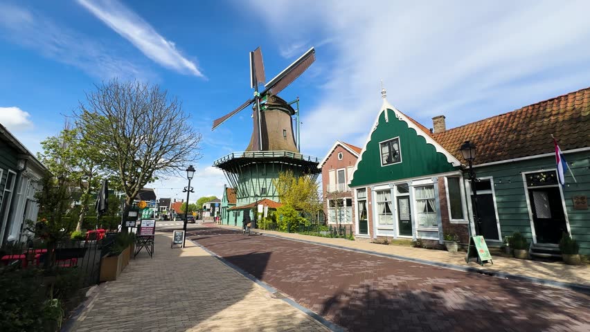 traditional Dutch windmills of Zaanse Schans over water at summer sunset, Netherlands