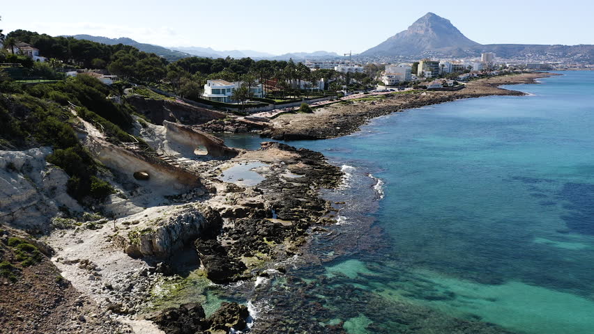 Aerial view of the beautiful rocky beach of Cala Blanca, in the bay of the town of Jávea, Mediterranean Sea, Spain.