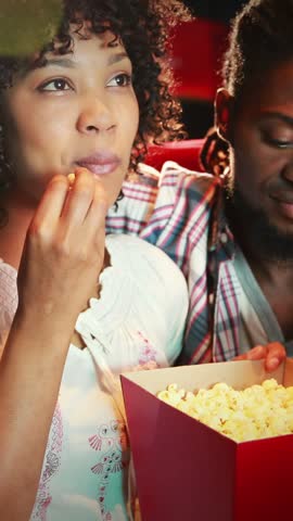 Cute couple watching a movie at the cinema