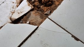 Broken and damaged ceramic floor tiles with exposed soil underneath. - Powered by Shutterstock - Get 15% off with code: PIKWIZARD15
