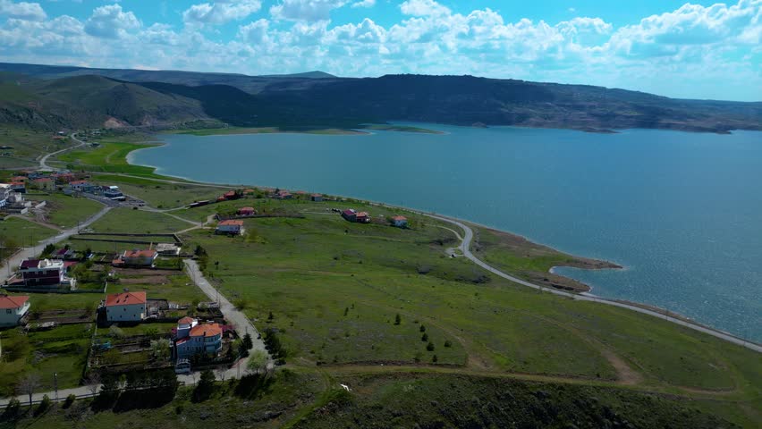 Aerial Panoramic Drone View of Green Valley with Lake in Background