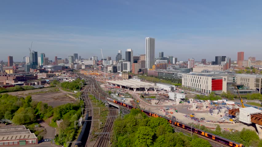 An aerial panoramic view of Birmingham cityscape skyline with the HS2 construction site and railway tracks running alongside University buildings on Curzon Street