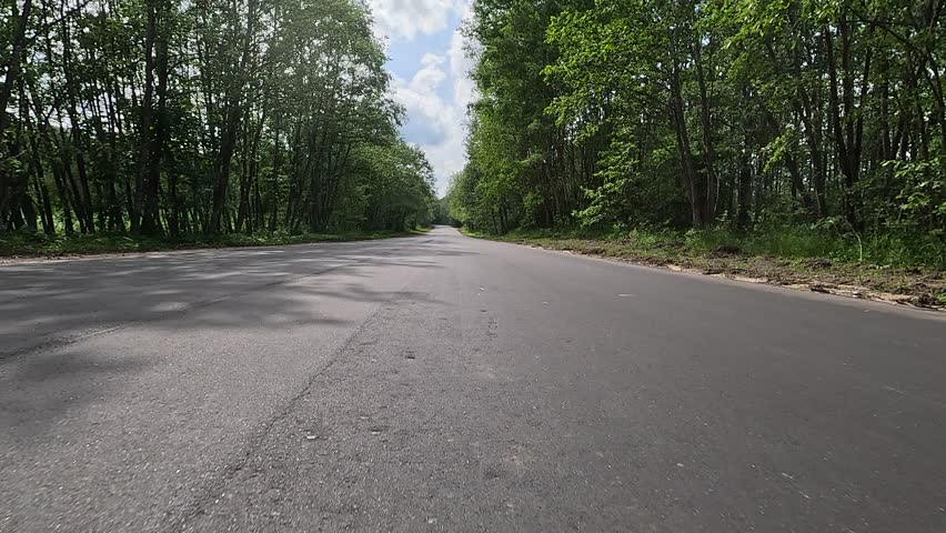 Video shooting in motion, driving a red car over the road along the asphalt at speed, view from the wheel.