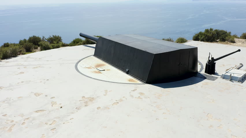 Drone view of the historic Bateria de Castillitos military coastal fortification, featuring the impressive Vickers 381mm naval guns and medieval-style architecture in Cabo Tiñoso, Spain. 