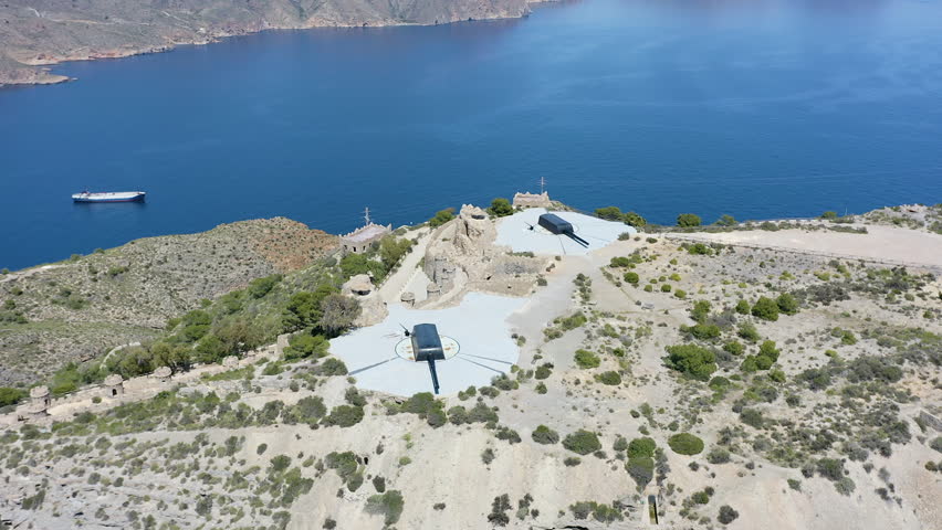 Drone view of the historic Bateria de Castillitos military coastal fortification, featuring the impressive Vickers 381mm naval guns and medieval-style architecture in Cabo Tiñoso, Spain. 