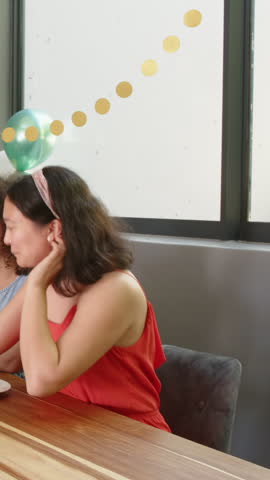 Vertical video: Chatting sparking Diverse women friends pouring drink into glasses at party table. Celebration, friendship, lifestyle, candid, joyful, interior, vertical video