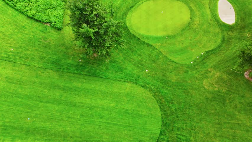 Stretches of vibrant fairways and roughs bounded by trees cascade across the landscape.