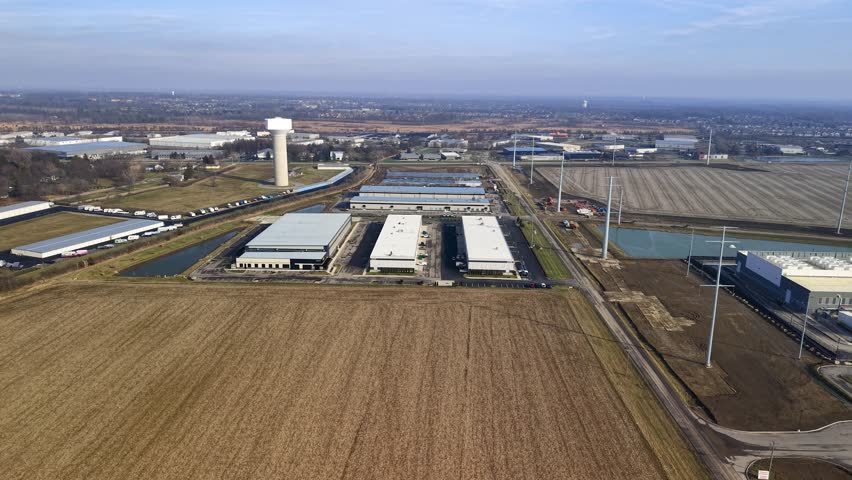 Aerial perspective of a modern industrial complex surrounded by agricultural fields and a water tower in Ohio.