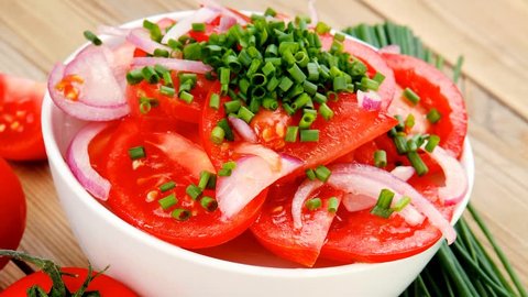 vegetable food : fresh tomato salad in white bowl with bundle of chives and raw tomatoes on twig over wooden table 1920x1080 intro motion slow hidef hd