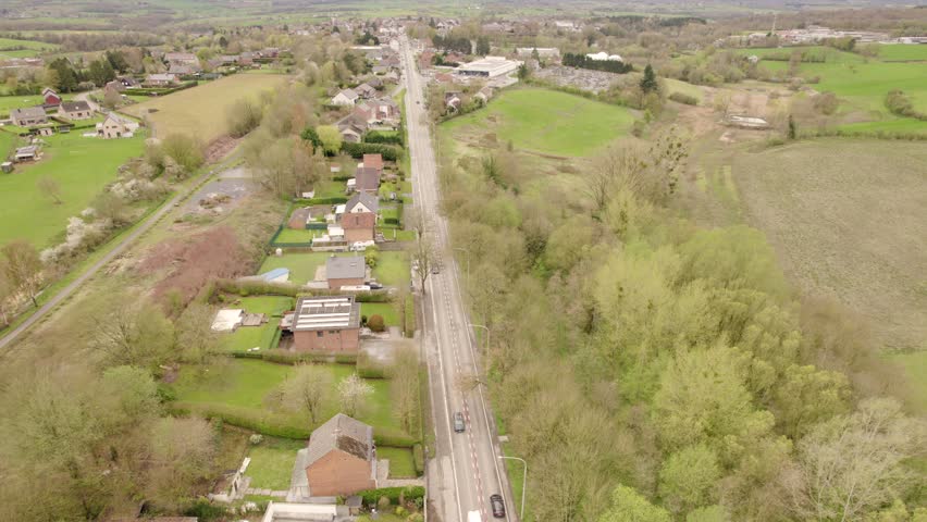 Aerial View Of The National Road Through A Residential Neighbourhood In The Countryside Of Belgium.
