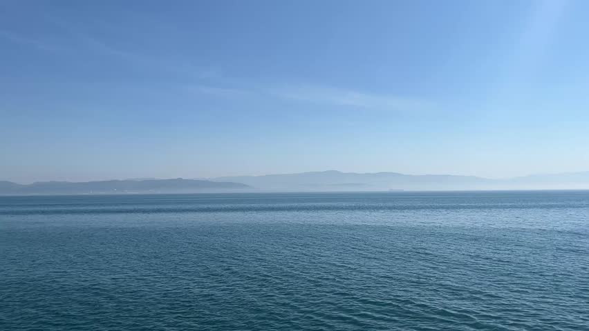 A vast view of the serene blue ocean meeting the clear blue sky.