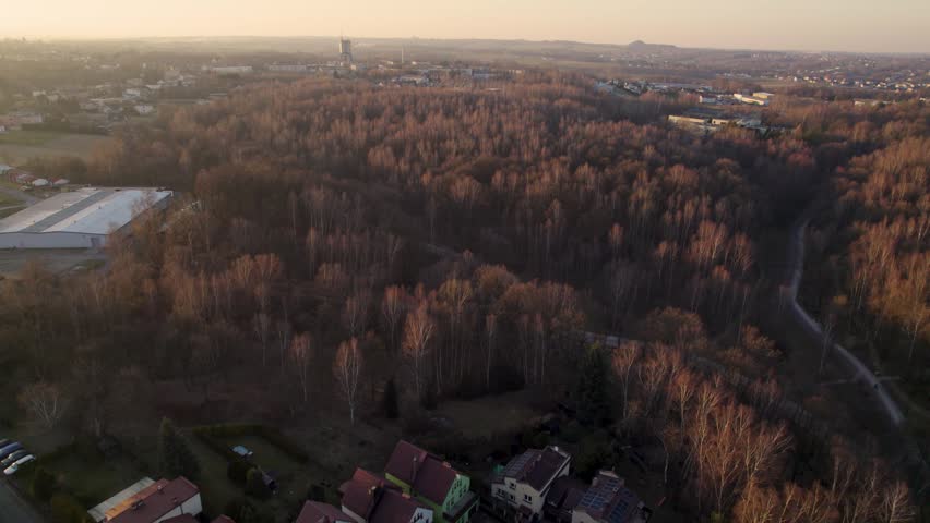 Aerial View of Industrial Mining Tower Behind Autumn Forest at Sunset