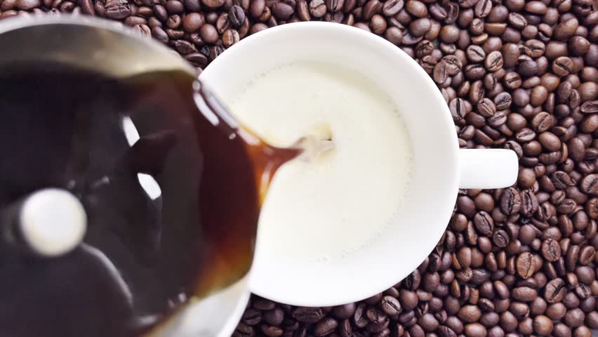 Pouring black coffee in cup. top view of coffee pour into cup from geyser coffee maker. coffee with froth	
