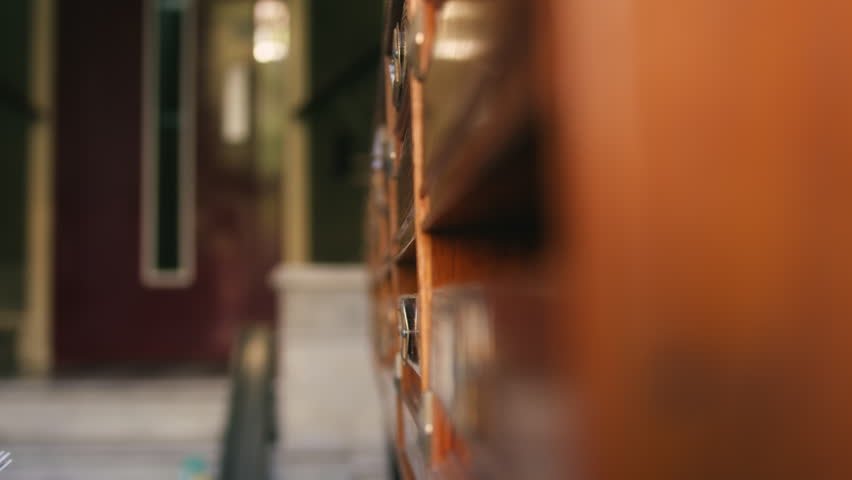 A close-up of a mail carrier placing a letter into a wooden mailbox. The scene captures postal service, communication, and traditional mail delivery. High quality 4k footage