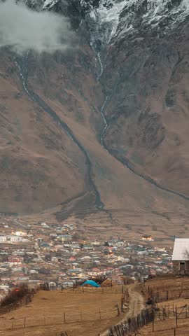 Stepantsminda, Georgia. Countryside Landscape At Evening Night Time On Mountain Background In Kazbegi District, Georgia. Road To Village In Autumn Season. Time Lapse Day To Night Transition