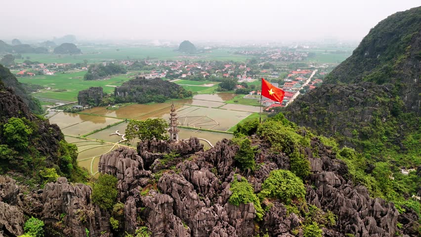 Vietnam flag waving over mua caves viewpoint and ninh binh