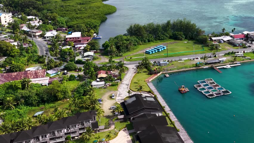 Aerial view of resort complex with lush greenery and swimming pools, dynamic aerial footage.