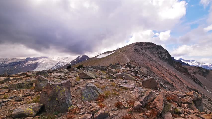 Footage capturing the rugged, high-altitude, tundra-like terrain of the Burroughs Mountain Trail in Mount Rainier National Park, Washington. The trail offers expansive, barren landscapes and stunning