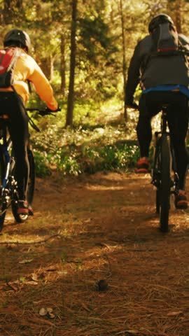 Mountain biking couple riding in the forest on a sunny day 4k