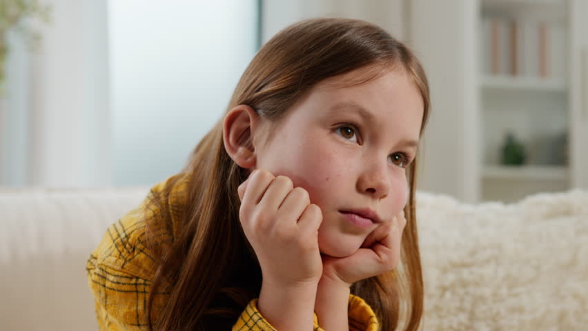 Thoughtful sad Caucasian child little girl kid daughter upset lonely bored stress boring at home thinking family custody problem think on couch childhood trouble childcare pediatric psychology help