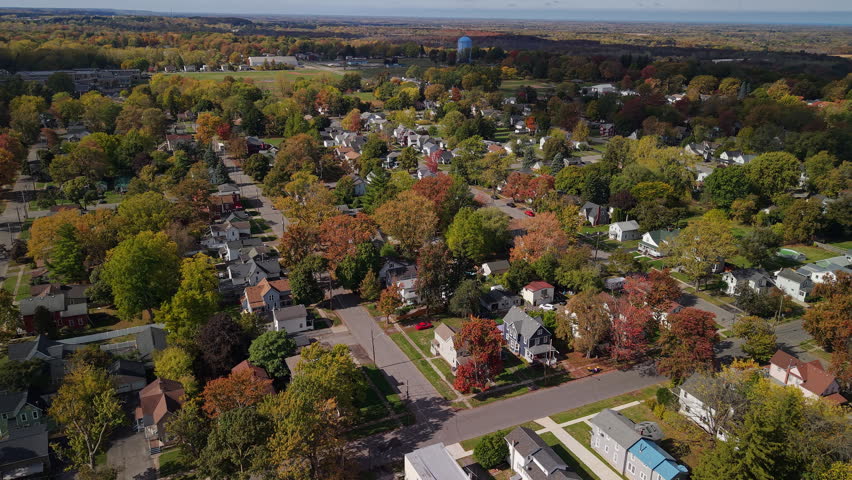 Aerial view of suburban neighborhood in the USA during autumn with colorful trees, houses and quiet residential streets.