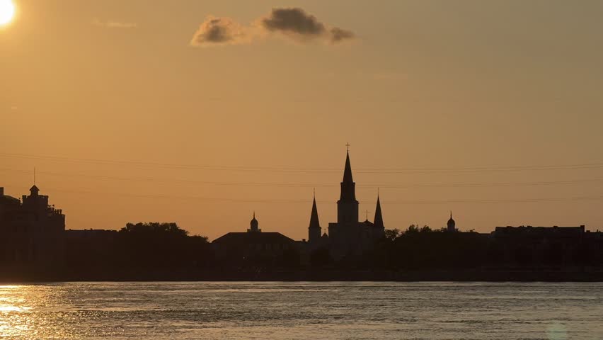 Timelapse of sun setting behind St. Louis Cathedral on the Mississippi River in New Orleans, Louisiana. 