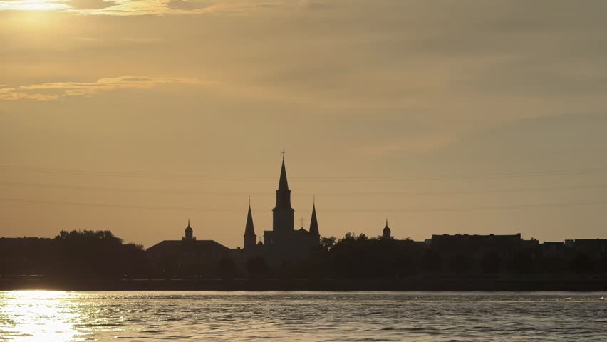 Timelapse of sun setting behind St. Louis Cathedral on the Mississippi River in New Orleans, Louisiana. 