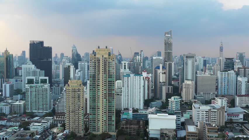 Drone view of Phaya Thai Bangkok showing dense skyline with Siamese Ratchakrue tower in foreground and Baiyoke Tower II in distance with modern high rise buildings and urban development