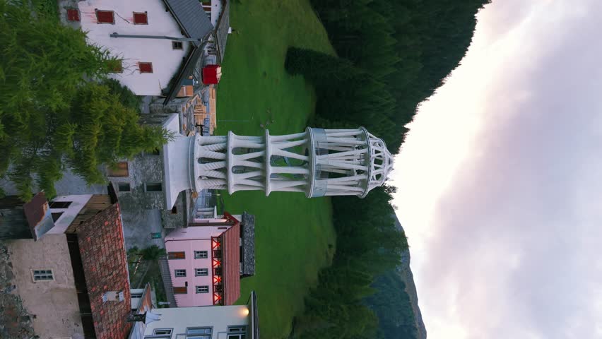 Juliusturm, a modern art installation, standing in a traditional Swiss alpine village. vertical video