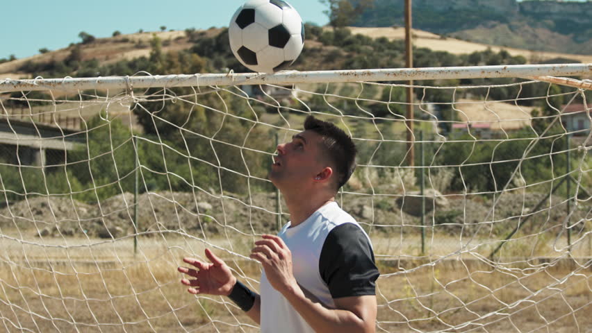 Soccer Player Dribbling The Ball In The Air With The Head