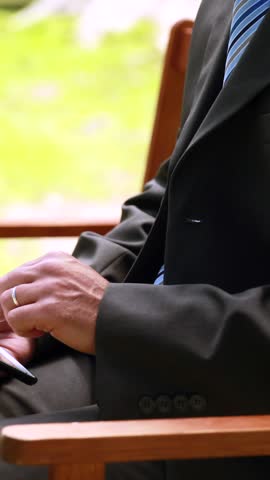 Businessman using tablet in the park on a sunny day