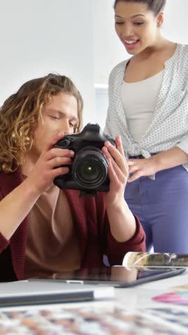 Photographers looking photographs on digital camera in studio 4k