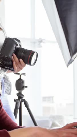 Photographers looking photographs on digital camera in studio 4k