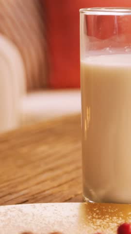 Christmas cookies on plate with a glass of milk on wooden table during christmas time 4k