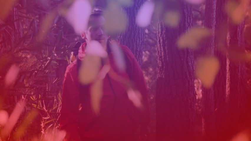 Man standing among trees, red subs graphic rising, revealing face, showing social media growth. Subscriber, notification, followers, forest, foliage, magenta, purple
