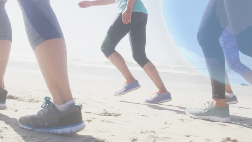 Four female runners starting fitness run along beach, steps initiating globe overlay across shadows. Silhouette, shoreline, backlit, stride, horizon, circles, network