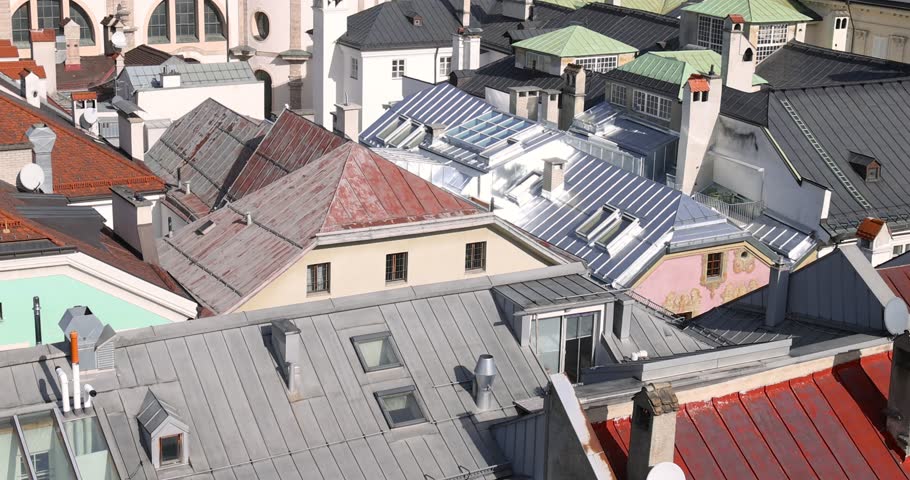High angle view panning across the colorful old roofs of Innsbruck, Austria, historic city center.