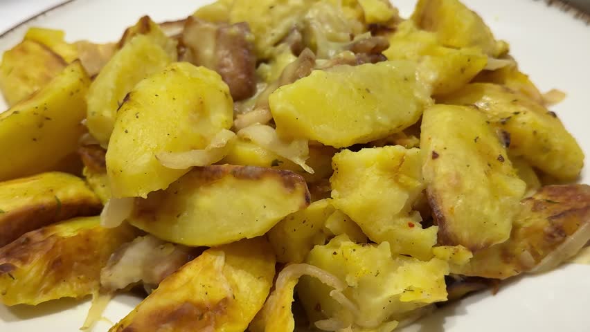 Grilled potato wedges with rosemary, cheese, salt and spices. Baked potato slices on a dark concrete background