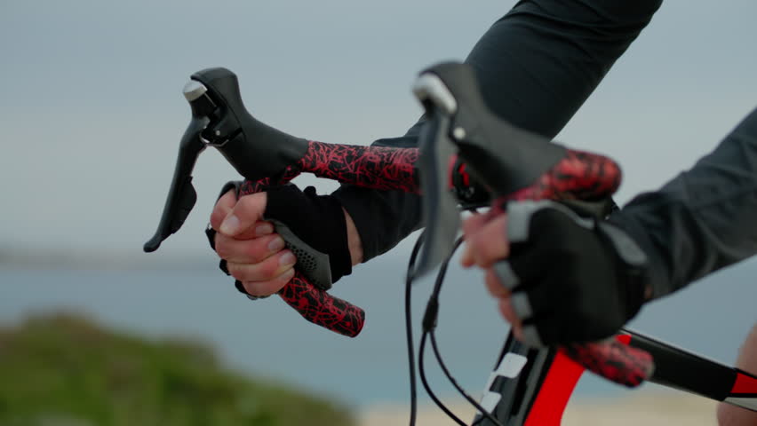 Close-up of male hands on bicycle handlebars while riding. Cycling and healthy lifestyle.