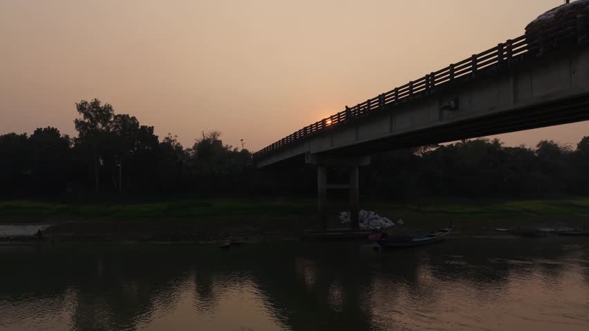 Sunset view of bridge over calm river at dusk