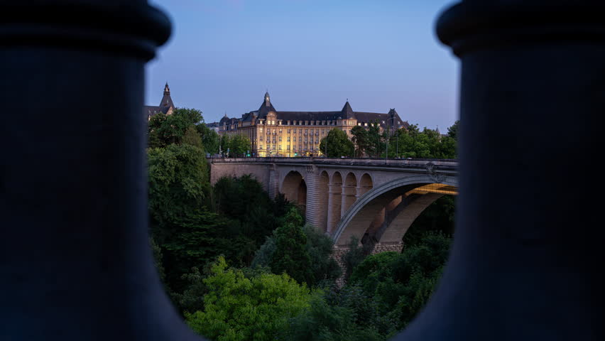 Timelapse clip of the Adolphe Bridge in Luxembourg City with the old historical buildings behind. The bridge was finished in 1903 and named after the Grand Duke Adolphe. Seen in the late blue hour