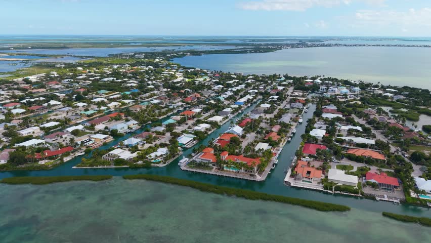 High-angle drone footage of a tropical residential community in the Florida Keys featuring a complex canal system and private boat docks.