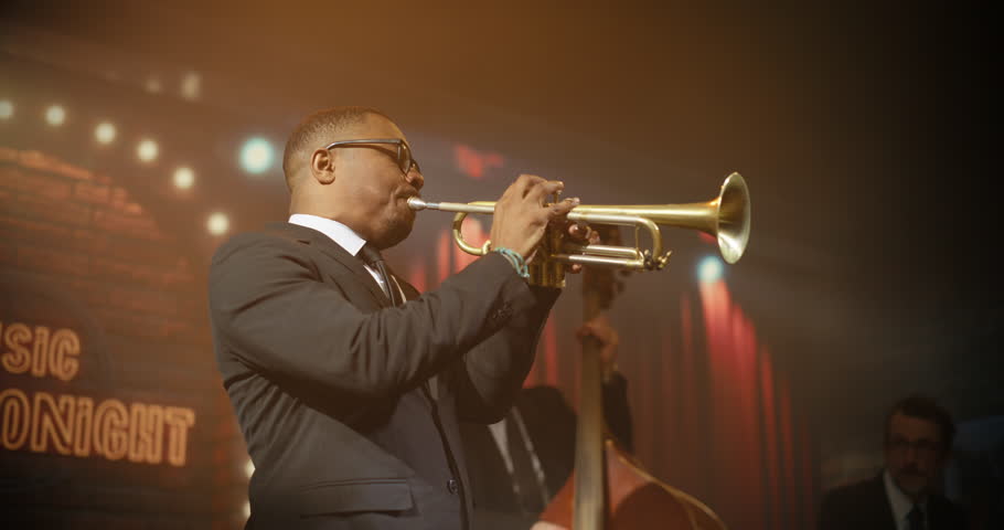 Portrait of Black Male Trumpeter Doing Solo Live Jazz Band on a Bar Stage, Playing a Soulful Song at a Concert Event While the Audience Enjoys the Music. Moving Stylish Medium Closeup