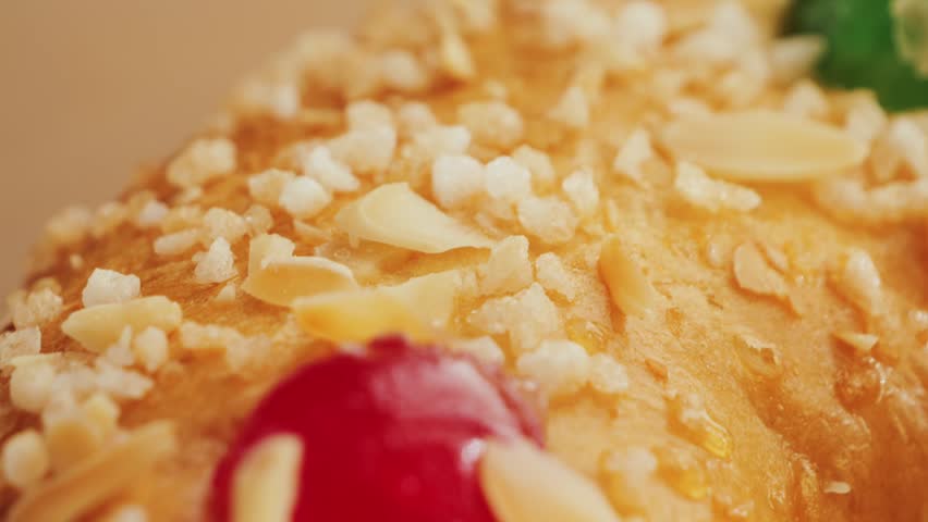 A sweet spanish cake Roscon de Reyes dessert topped with almonds, berries, and candied fruit. High quality 4k footage