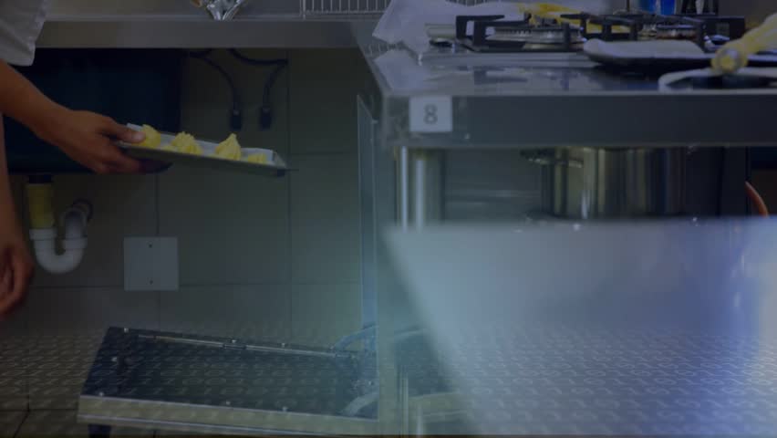 Hands delivering yellow dough tray initiating wireframe cube chef placing tray on rack for baking. Kitchen, industrial, stainless, counter, professional, focus, station