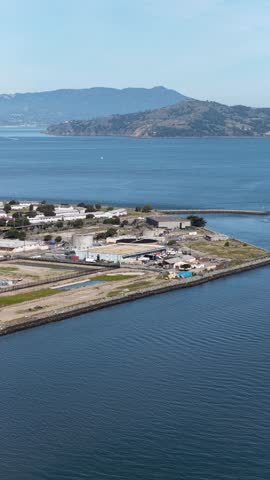 Beautiful aerial perspective of Treasure Island, a man-made island in the San Francisco bay, showing its coastline and the surrounding calm blue waters on a clear, sunny day in California